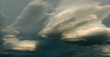 Manzaralı yuvarlak mercek bulutları muhteşem kreusküler ışınlar ve mistik bir altın saat alacakaranlığı ile çevrili ışık efektleriyle zamanlanırlar. Garip atmosferik fenomen sinematik çekim için kilitlendi.