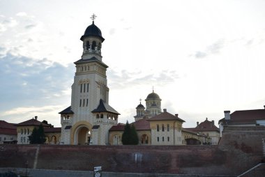 Mimar Victor Stefanescu 'nun planlarına göre, Romanya Kraliyet Sarayı' nın desteğiyle Kutsal Üçleme 'ye adanmış çan kulesi Alba Iulia' daki Taç Giyme Katedrali 'ne bakın.