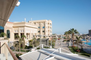 Ağaçlarla ve farklı renkte süslü çalılarla, desenli dekoratif yapraklarla her zaman yeşil yüzme havuzlarının ve doğu tarzında binaların yanında