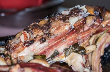 Yeşil soğanlı kuzu biftek, sarımsak, jambon, domuz yağı ve bol kaliteli şarapla iki kez serpilmiş.