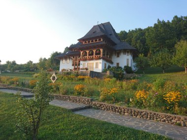 Sanatçının Barsana 'daki evi, manastıra gelen sanatsal eğilimleri olan insanları barındırmak için oyulmuş ahşap sütunları ve eğimli sundurması olan eğimli bir binadır.