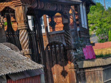 Maramures kapısı, meşe ağacından yapılmıştır, genellikle farklı geleneksel çiçek motiflerine sahip en az üç sütun ve kapının üst eşiği kiremitlerle kaplıdır.