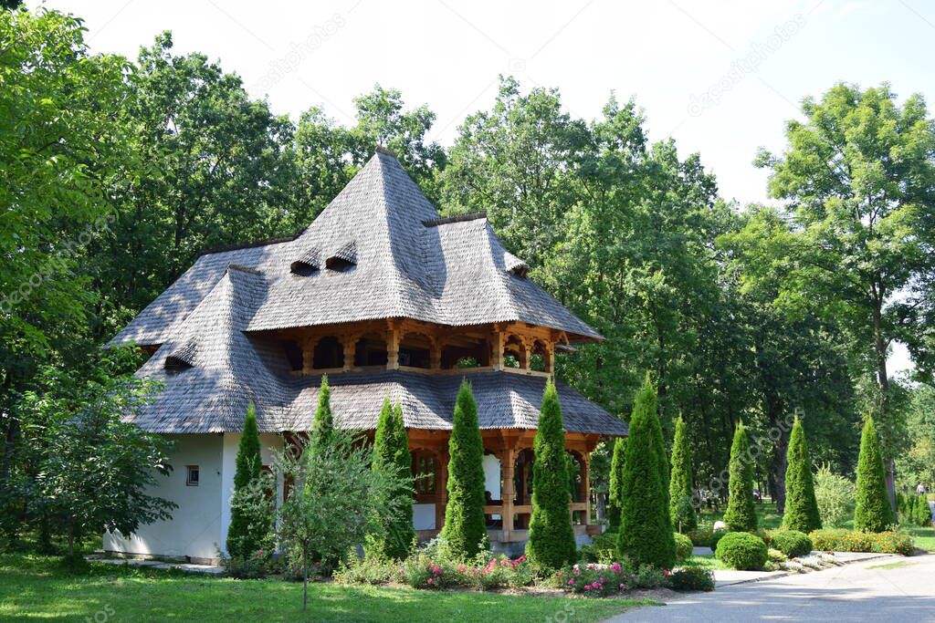 The shop of the Sapanta Maramures monastery. Building on two levels in Maramures style with lacy wooden shingled roofs is located laterally and is the first building visible up close
