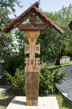 Yolun kenarındaki haç, ortodoks haç ve güneş rozetlerinin baskın olduğu motiflerle tahtadan oyulmuştur. Kötü ruhları uzak tutmak için çatal ve yol kesişimlerinde bulunur.