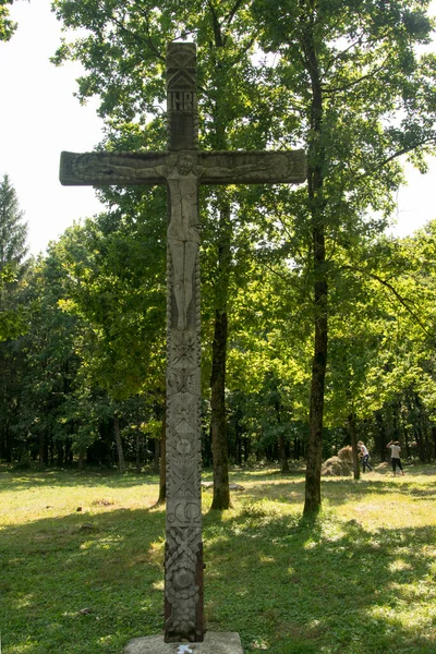 道路の横にある十字架は木から彫刻され 正教会の十字架と太陽のロゼットが悪霊を追い払うためにフォークと道路の交差点に位置しています — ストック写真