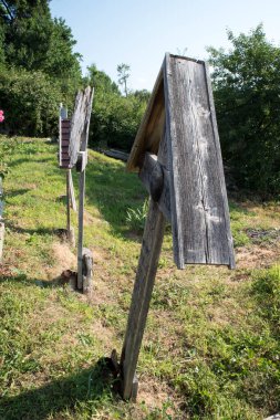 Novaci-Foreign 'in ahşap kilisesindeki ortodoks haçı, ahşap ahşaptan yapılmış, ve motiflerle yontulmuş, iple gökyüzü ile yeryüzü arasındaki bağlantıyı temsil eden ya da güneşe hakim olan kolyenin motifini temsil eden. 