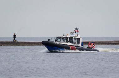 SWINOUJSCIE, BALTIC SEA / POLAND - 2019: A Polish Border Guard patrol boat with an oil tanker in the background clipart