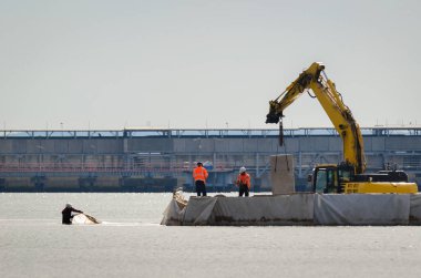 BİR SEAPORT 'ta KONUŞMA Çalışması - Kazıcı ve inşaat alanında çalışan işçiler
