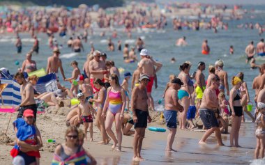 SARBINOWO, BATI POMERANYA / POLAND - 2021: Tatilciler gezinti güvertesi boyunca yürüyorlar