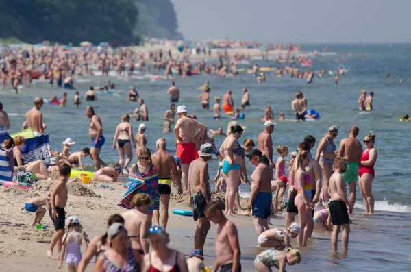 SARBINOWO, BATI POMERANYA / POLAND - 2021: Tatilciler gezinti güvertesi boyunca yürüyorlar 