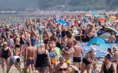 SARBINOWO, BATI POMERANYA / POLAND - 2021: Güneşli deniz plajında tatilciler yeniden yaratılıyor