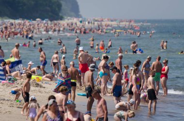 SARBINOWO, BATI POMERANYA / POLAND - 2021: Güneşli deniz plajında tatilciler yeniden yaratılıyor