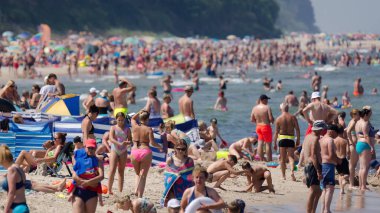 SARBINOWO, BATI POMERANYA / POLAND - 2021: Güneşli deniz plajında tatilciler yeniden yaratılıyor