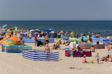 SARBINOWO, BATI POMERANYA / POLAND - 2021: Güneşli deniz plajında tatilciler yeniden yaratılıyor