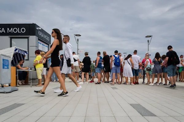 KOLOBRZEG, Batı POMERANYAN - POLAND - 2021: Gezinti güvertesinde tatilciler ve iskele giriş biletleri için gişede kuyruk