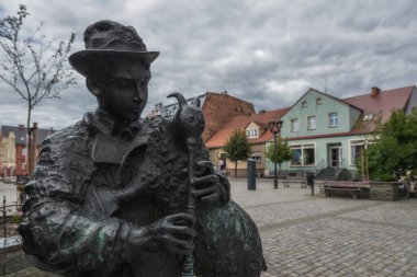 ZBASZYN, GREATER POLAND - POLAND - 22 AĞUSTOS 2025: MARKET KARPI - Yerel gayda enstrümanına sahip bir folk müzisyeni, keçi
