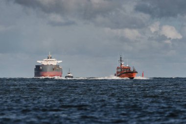 SUÇLU, BATI POLAND - 23 Eylül 2025: MARITIME TRANSORT - Pilot tekne, römorkörler ve gemi limana doğru yelken açıyor