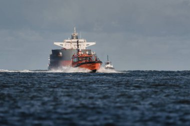 SUÇLU, BATI POLAND - 23 Eylül 2025: MARITIME TRANSORT - Pilot tekne, römorkörler ve gemi limana doğru yelken açıyor