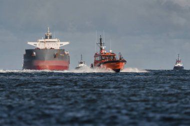 SUÇLU, BATI POLAND - 23 Eylül 2025: MARITIME TRANSORT - Pilot tekne, römorkörler ve gemi limana doğru yelken açıyor