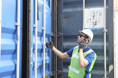 İş adamı ya da Foreman kontrol kargodan konteynır kutusu yükleme ve müfettiş ihracat şirketi lojistik şirketi ayrılmadan önce konteynır kutusunu nakliye konteynırlarıyla kontrol ediyor