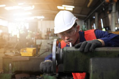 Fabrika mühendisi büyük makine çalıştırıyor. Endüstri konsepti için malzemeyi kesti.