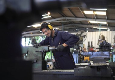 Fabrika mühendisi büyük makine çalıştırıyor. Endüstri konsepti için malzemeyi kesti.