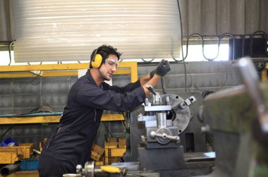 Fabrika mühendisi büyük makine çalıştırıyor. Endüstri konsepti için malzemeyi kesti.