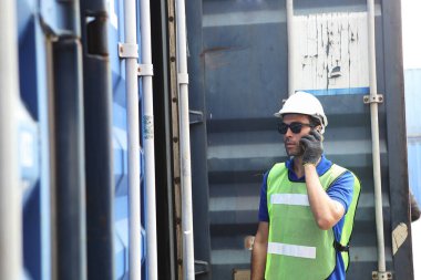 İşçiler kargo konteynırlarını inceliyor. ayrılmadan önce.