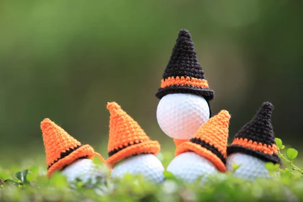 ゴルフコースの背景のホリデーシーズンのコンセプトのためのハロウィンの帽子とティーの上のゴルフボール — ストック写真