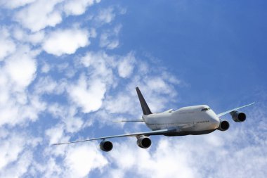 Gün batımında, ticari uçak, ulaşım, ithalat-ihracat ve lojistik, seyahat konseptiyle iş gezisi için bulutların üzerinde renkli gökyüzü ile büyük beyaz bir uçak uçuyor. 