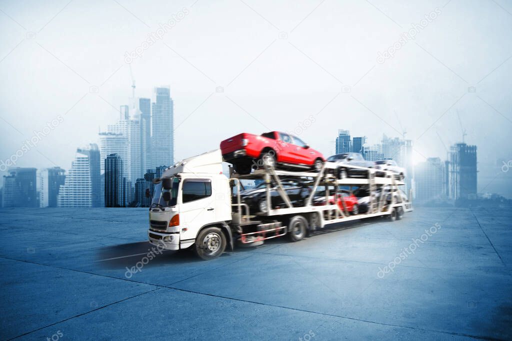 The trailer transports cars on highway with big city background