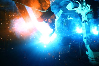 Kaynak robotları hareketi temsil ediyor. Otomotiv parçaları endüstrisinde.