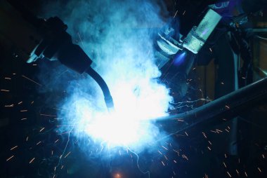 Akıllı fabrika arka planında kablosuz robot kolu. Otomotiv parçaları endüstrisindeki kaynak robotu medyası