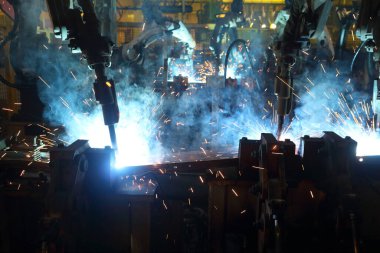 Akıllı fabrika arka planında kablosuz robot kolu. Otomotiv parçaları endüstrisindeki kaynak robotu medyası