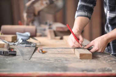 Carpenter, marangoz atölyede çalışıyor. Ahşap üzerinde çalışan bir adam. Atölyedeki olgun marangoz imajı, mobilya yapma konsepti..