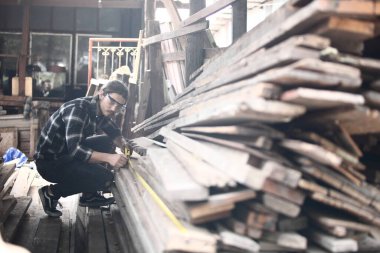 Marangoz, atölyede çalışıyor. Tahta üzerinde çalışan bir adam. Atölyedeki olgun marangoz imajı, mobilya yapma konsepti..