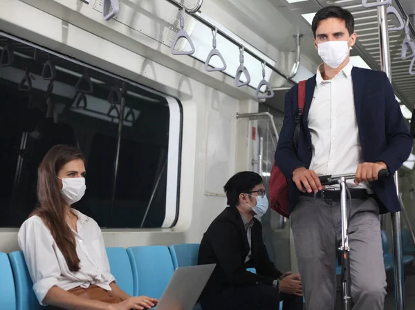 people with mask travel Public electric train, Businessman or woman wearing white facial mask during travel by Public electric train, new normal life style during covid-19 pandemic