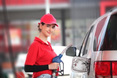  Benzin istasyonunda kırmızı üniformalı bir kadın, arabaya yakıt ikmali yapan genç bir kadın ya da modern benzin istasyonunda yakıt pompası başlıklı genç bir kız. 