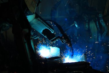 Akıllı fabrika geçmişinde robot kolu. Otomotiv parçaları endüstrisindeki kaynak robotu medyası