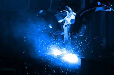 Akıllı fabrika geçmişinde robot kolu. Otomotiv parçaları endüstrisindeki kaynak robotu medyası