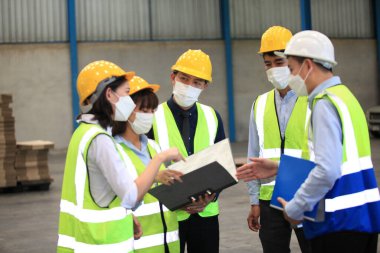 Ekip çalışanları güvenlik endüstriyel fabrikası için koruyucu maskeler takıyorlar. Fabrikada ya da depoda çalışmaya başlamadan önce işçi toplantısı