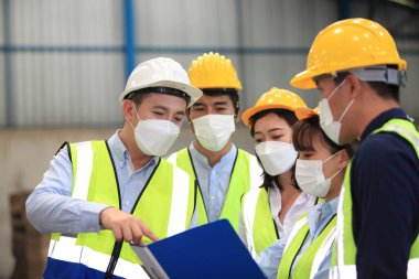 Ekip çalışanları güvenlik endüstriyel fabrikası için koruyucu maskeler takıyorlar. Fabrikada ya da depoda çalışmaya başlamadan önce işçi toplantısı