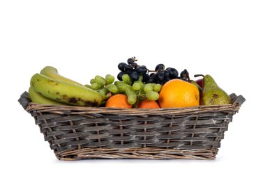 Örülmüş meyve sepeti kıvamında çeşitli meyveler var. Beyaz bir arkaplanda izole edilmiş.