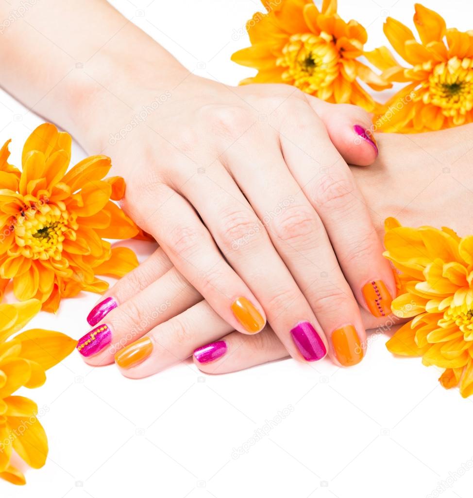 Women's hands with bright manicure and flowers around