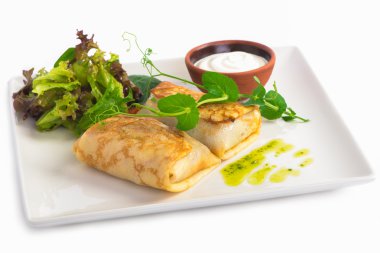 Krep zorla et yeşil taze salata ve beyaz tabakta ekşi krema ile