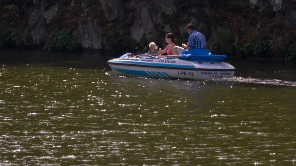 Familie schwimmt auf kleinem Boot entlang der Küste auf dem Stausee — Stockfoto