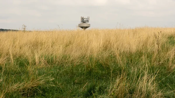 Top of the water tank with radio transmitters in the grass field — Stock Photo, Image