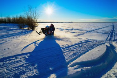 Karmobil karlı bir alanda güneşli günde uçar. .