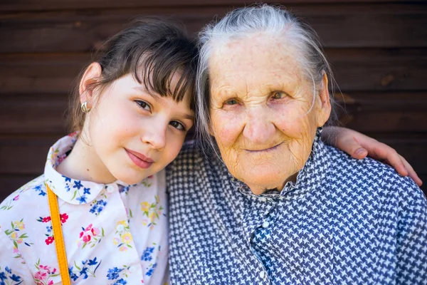 Büyük-büyükannesi ve torununun oturma kol kola. — Stok fotoğraf