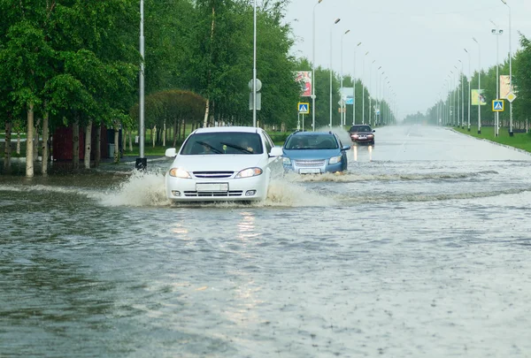 車の都市の路上で巨大な水たまりを交差点. — ストック写真